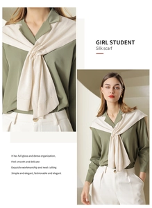 Detail of beige knitted shawl wrap showing smooth texture and elegant office styling