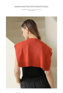 Detail of orange knitted shawl featuring high-density weaving and smooth stitching