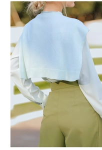 Detailed close-up of light blue gradient knit shawl worn over a white shirt