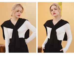 Detail of white ribbed long sleeve top paired with a black knitted sweater shawl wrap