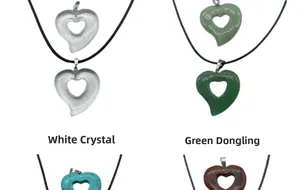 Detail of hollow heart pendants in white crystal and green aventurine with black cords