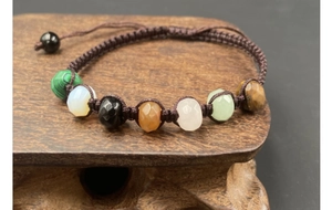 Macro detail of hand-woven bracelet with seven faceted natural crystal gemstones