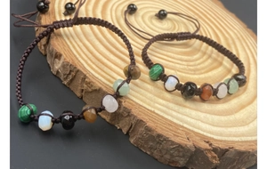 Close-up of handmade woven bracelets with colorful natural gemstone beads on wood