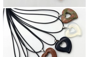 Detailed view of heart-shaped crystal pendants in four different natural stone textures