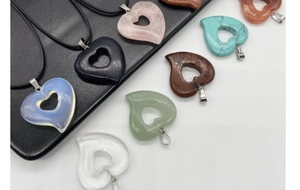 Detailed view of hollow heart pendants made of assorted natural semi-precious gemstones