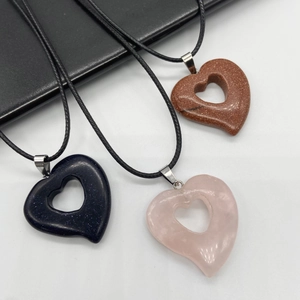 Hollow heart necklaces in blue sandstone, goldstone, and rose quartz on black cords