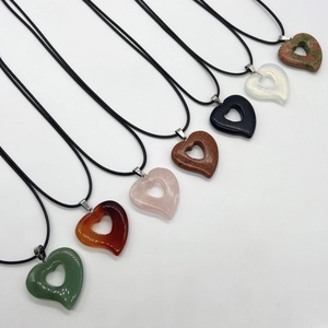 Collection of seven heart-shaped stone pendants in crystal, agate and quartz on black cords