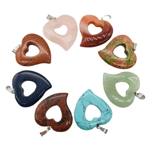Set of eight heart-shaped natural crystal pendants with silver heart clasps on white background