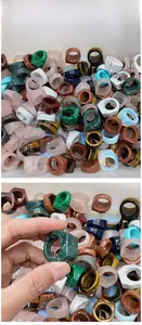 Detailed view of wide square rings in diverse natural stone textures like tiger eye and malachite