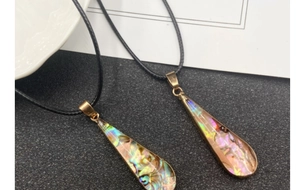 Detail of abalone shell teardrop pendants with gold plated edges on black cords