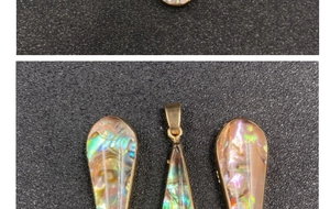 Detailed macro view of colorful abalone shell pendants with golden metal gilded edges