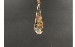 Close-up of golden teardrop pendant with iridescent colorful abalone shell inlay