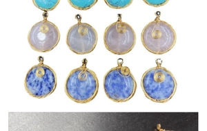Macro detail of handmade gold wire wrapped semi-precious stone pendants with spiral design