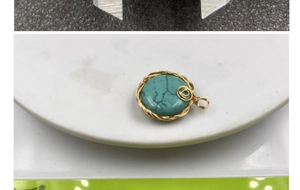 Macro shot of turquoise pendant with wire wrapping on a digital scale for quality inspection