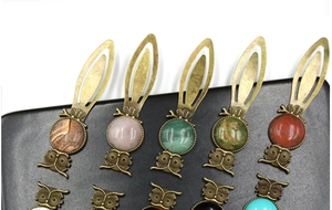 Detail view of vintage owl bookmarks with assorted colorful gemstones on bronze alloy metal