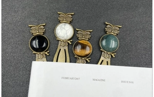 Detail of vintage owl bookmarks in bronze alloy featuring four colorful natural stone accents