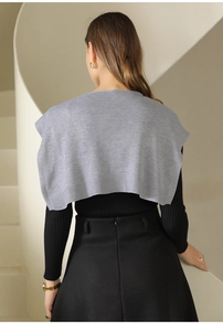 Elegant grey knitted shawl layered over black attire for minimalist style back view