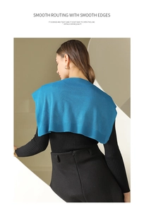 Detail of navy blue knitted shawl showing dense texture and smooth routing on model