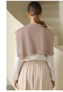Rear view of elegant brown knitted shawl paired with white shirt and beige skirt