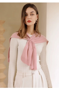 Close-up of pink knitted shawl wrap with textured cable stitch patterns for women