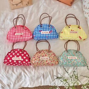 Semicircle canvas wrist bags with floral and plaid patterns and leather straps
