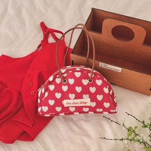 Vintage semicircular red canvas handbag with white heart pattern and leather handles