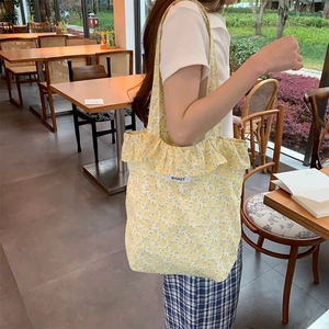 Yellow floral canvas tote bag with ruffle trim and Bisket label for casual style