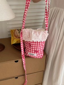 Detailed view of red checkered crossbody bag with lace embroidery and Bisket fabric label