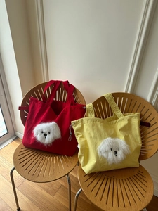 Detail of canvas tote bags featuring 3D plush puppy face and drawstring closure