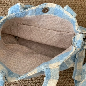 Detail of plaid canvas bag interior showing magnetic clasp and internal pocket