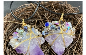 Detailed macro view of handmade gold wire-wrapped amethyst pendants with pearls and shells