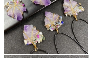 Macro view of handmade amethyst crystal pendant with wire wrap detail and small pearls