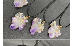 Macro shot of handmade gold wire-wrapped raw amethyst crystal pendants with pearl accents