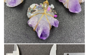 Macro detail of handmade wire-wrapped amethyst crystal pendant with shell accents