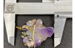 Detail of amethyst cluster wrap pendant being measured with caliper showing 45mm width