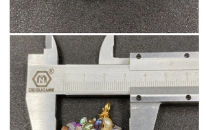 Macro detail of handmade amethyst pendant measuring 3cm with gold wire wrap and pearl