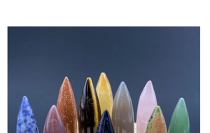 Polished bullet-shaped crystal stones including tiger eye, rose quartz and aventurine jade