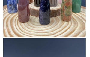 Polished natural crystal bullet stones displayed on a rustic wooden base with organic textures