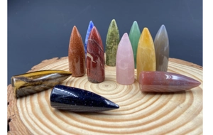 Polished crystal agate bullet-shaped energy stones set on a wooden base display