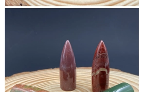 Macro view of polished bullet-shaped crystal stones on a wooden tray with natural textures