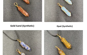 Detailansicht von drahtumwickelten hexagonalen Kristallanhängern mit goldenem Drahtband