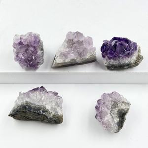 Ensemble de cinq amas de cristaux d'améthyste naturelle avec dégradé violet sur fond blanc