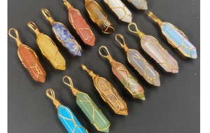 Details von sortierten Kristall-Anhängern mit goldener Drahtwicklung in vielen Farben