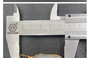 Nahaufnahme der 48,5 mm Breite eines drahtumwickelten grünen Kristall-Hexagon-Anhängers