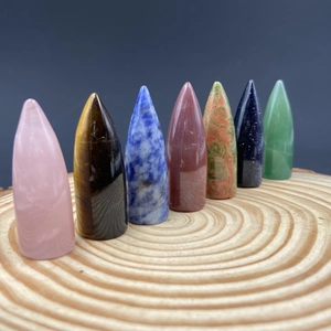 Polished hexagonal crystal bullet points in mixed gemstones on a wooden base
