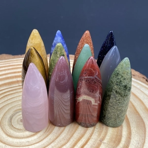 Polished bullet shaped natural crystal stones and gemstones on wooden background