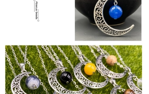 Détail du pendentif lune évidé avec perles de pierres précieuses rotatives en argent