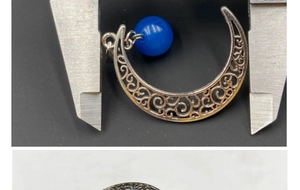 Vue détaillée du pendentif lune évidé montrant une largeur de 3,0 cm sur un pied à coulisse