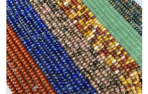 Macro view of assorted natural stone abacus beads including lapis and tiger eye
