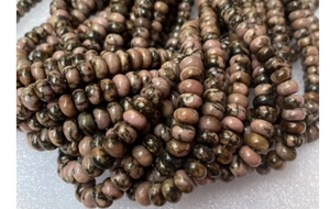 Macro detail of natural pink rhodonite abacus beads with unique black stone patterns